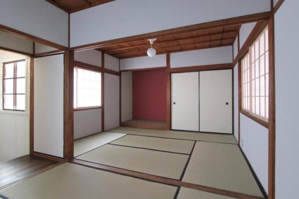 an empty room with white walls and windows at Hashibaya TABI-NE in Kanazawa