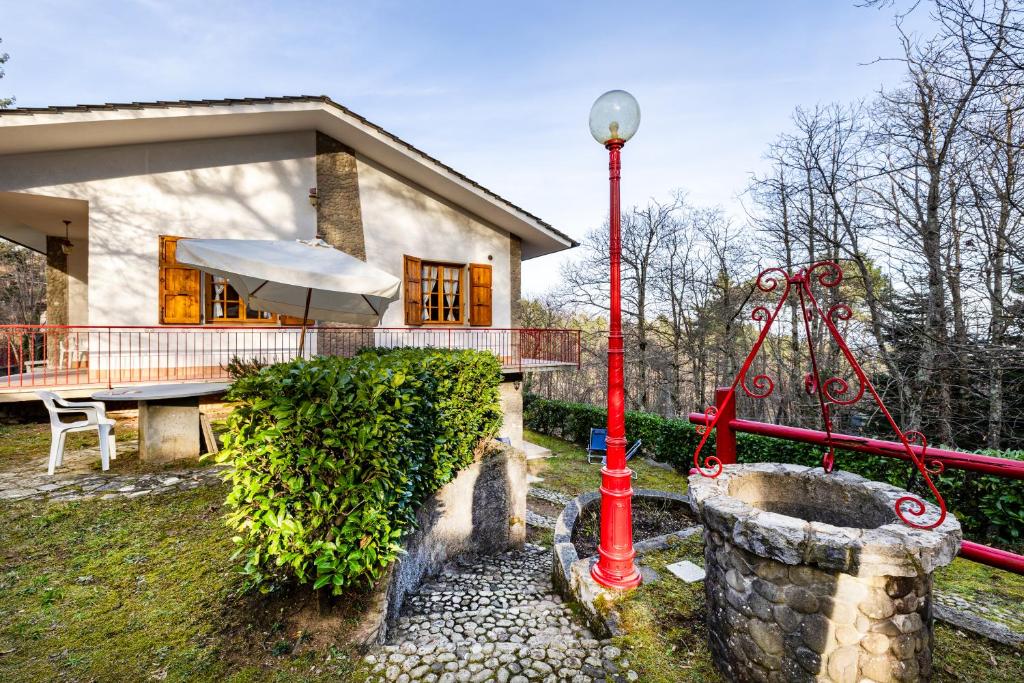 una casa con un palo rosso davanti di Comfortable Home Vittoria Among Greenery - Happy Rentals a Marliana