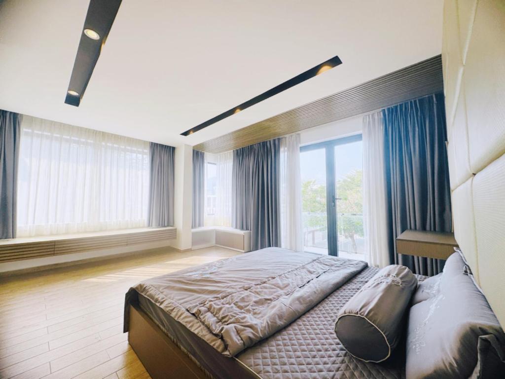 Villa 2M في نها ترانغ: غرفة نوم بسرير كبير ونوافذ كبيرة