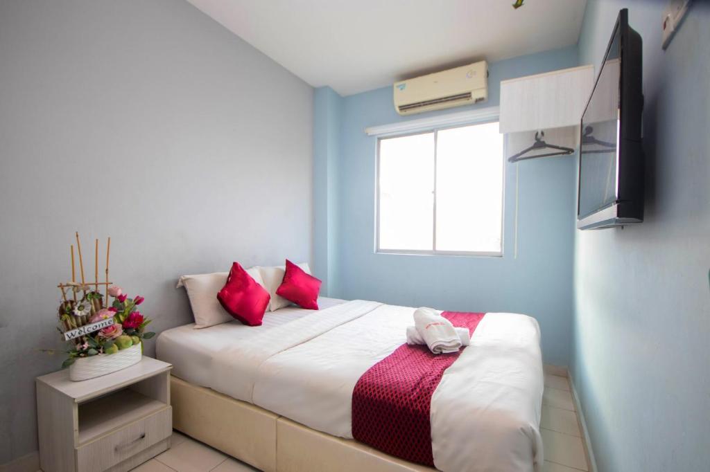 マラッカにあるSun Inns Hotel Kota Laksamana Melakaのベッドルーム1室(ピンクの枕が付くベッド1台、窓付)