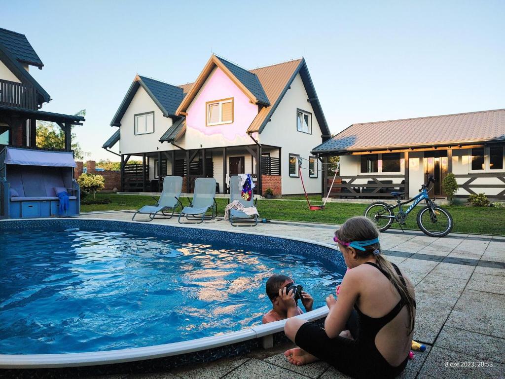 Eine Frau, die ein Foto von einem Mann im Schwimmbad macht. in der Unterkunft Luxury holiday homes with swimming pool, jacuzzi in Rewal
