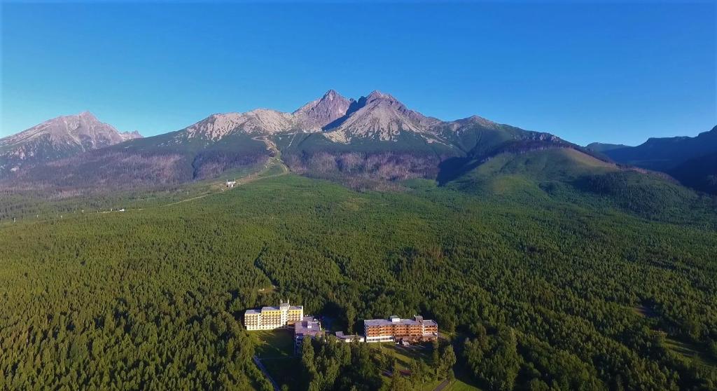 Hotel SOREA HUTNÍK I. في Vysoke Tatry - Tatranske Matliare: اطلالة جوية على جبل مع مبنى على تلة