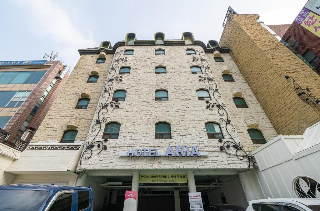 un gran edificio de ladrillo con un cartel hotelero de arma en Hotel Aria, en Pyeongtaek