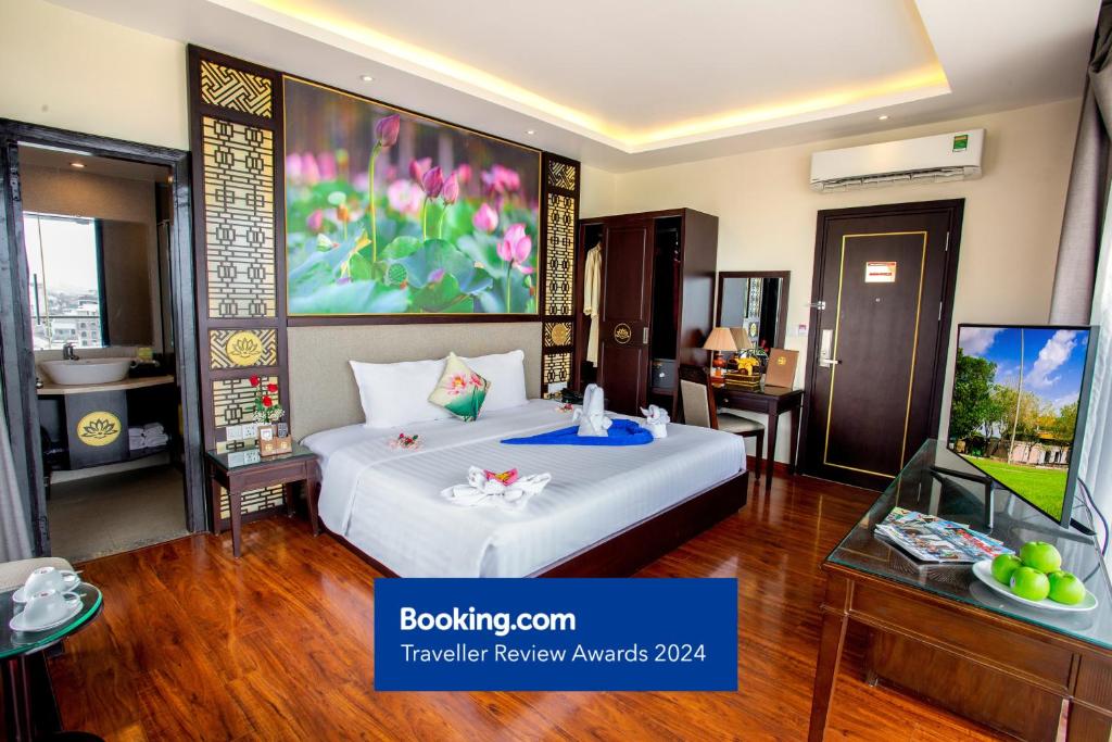 a hotel room with a bed and a tv at Thanh Lich Hue Hotel in Hue