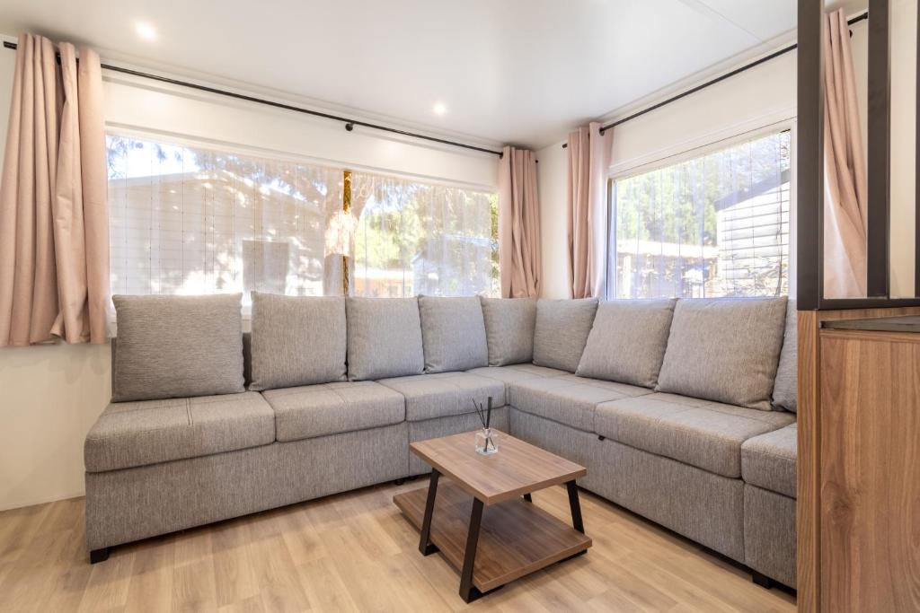 a living room with a couch and a table at Mobilhome Soleia 2023 Mar Estan 4x in Canet-en-Roussillon