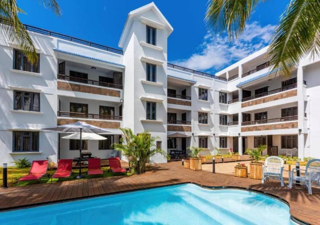 una imagen del exterior de un edificio con piscina en Les Cerisiers - Exclusive Beach Residence Flic en Flac, en Flic en Flac