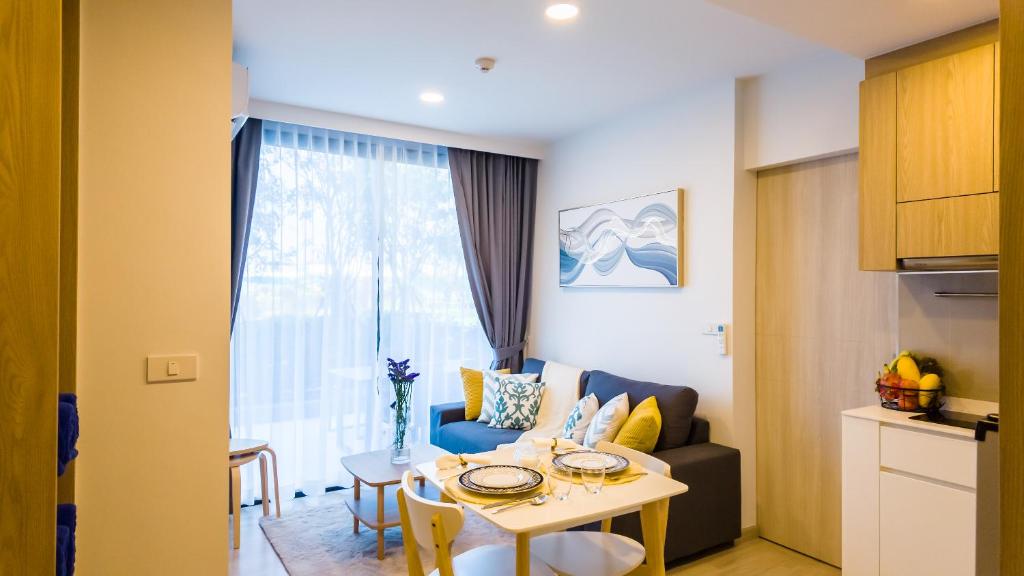 un soggiorno con tavolo e divano di Апартаменты в Laguna Skypark с террасой a Bang Tao Beach