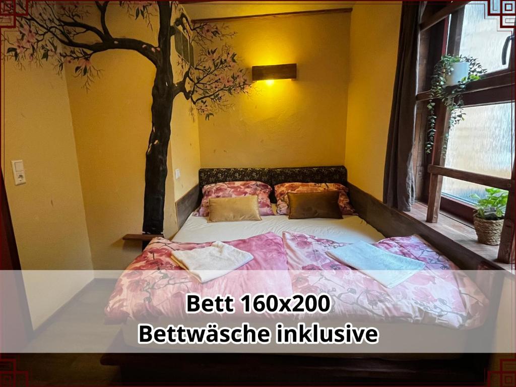 a bedroom with a bed with a tree on it at SmallSaigon Apartment mit guter Anbindung in Leiningen