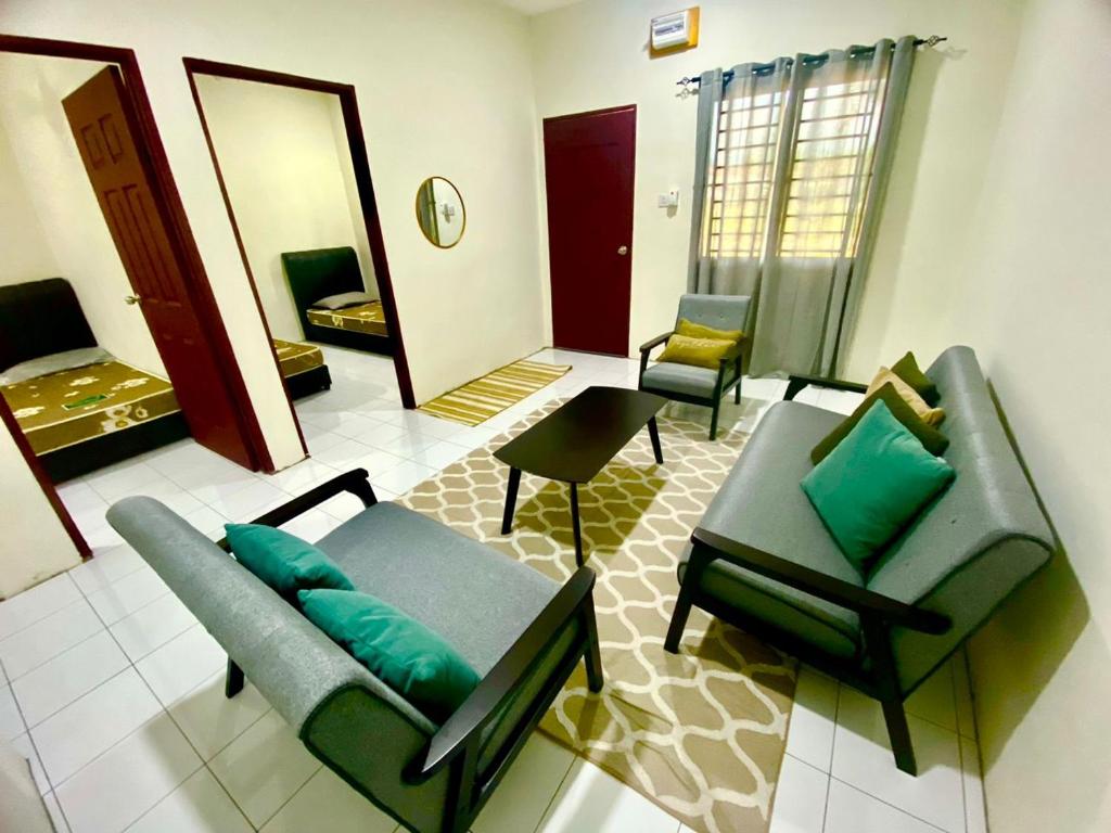 Suhana LongHouse HomeStay Sipitang في Sipitang: غرفة معيشة مع كرسيين وأريكة