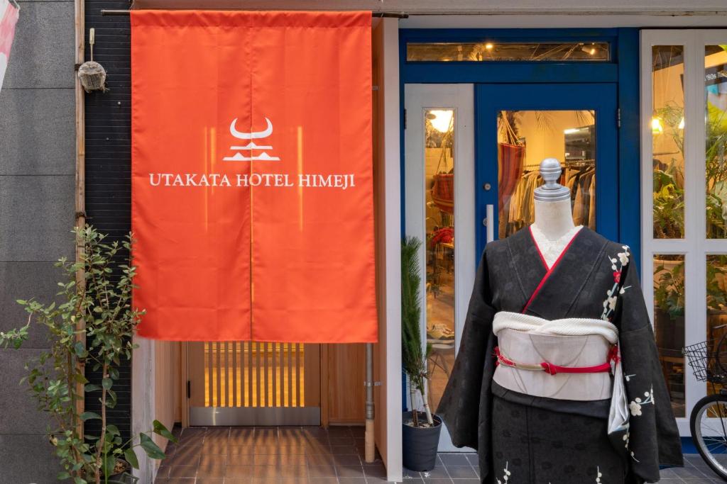 a mannequin in front of a building with a flag at UTAKATA HOTEL HIMEJI in Himeji