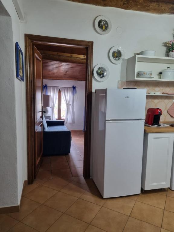 een keuken met een koelkast en een kamer met een bank bij Appartamento “Il Borgo” in Peccioli