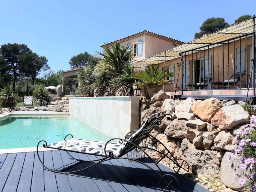 a chair sitting on a deck next to a swimming pool at BELLA VISTA 1 chambre d&#39;hôtes 2 personnes in Salernes