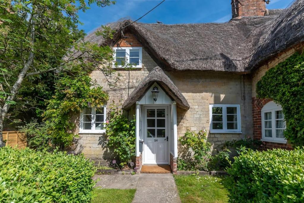 an old stone house with a thatched roof at Alba Cottage, Wilcot, Pewsey in Wilcot