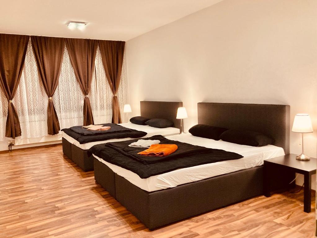 two beds in a bedroom with two lamps and windows at Luxury Premium Apartments in Bonn