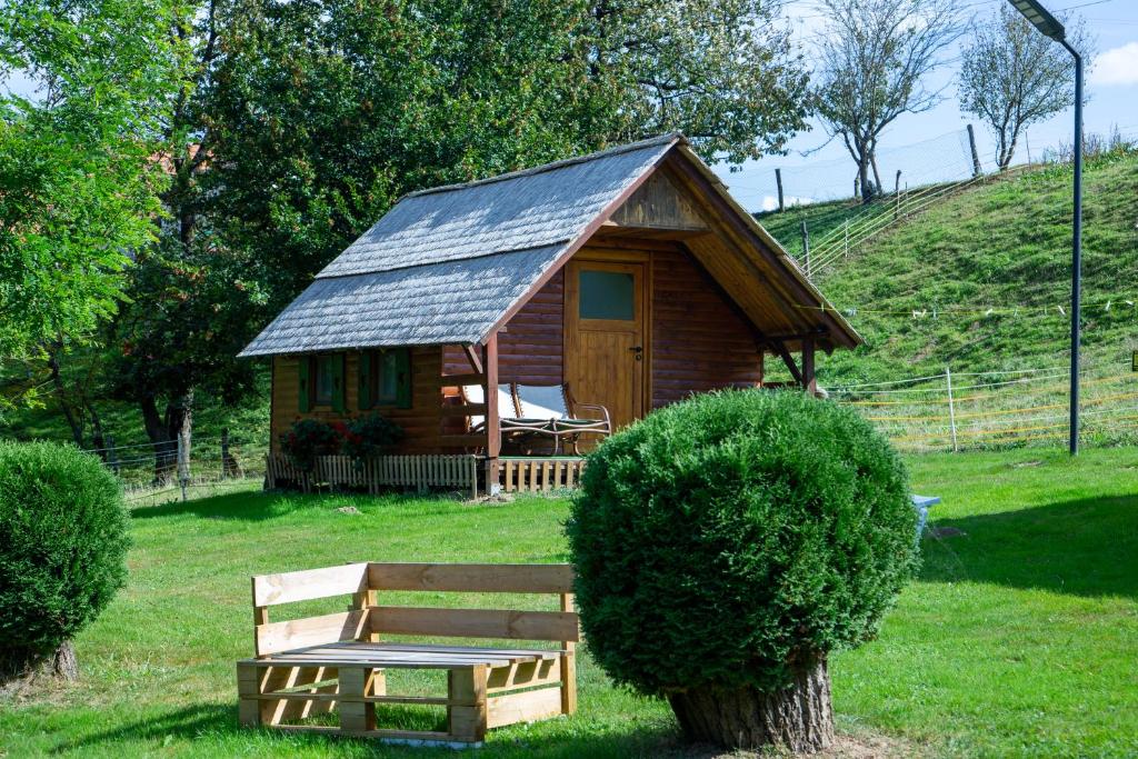 a small wooden cabin with a bench in the grass at Camping Silva in Ljutomer