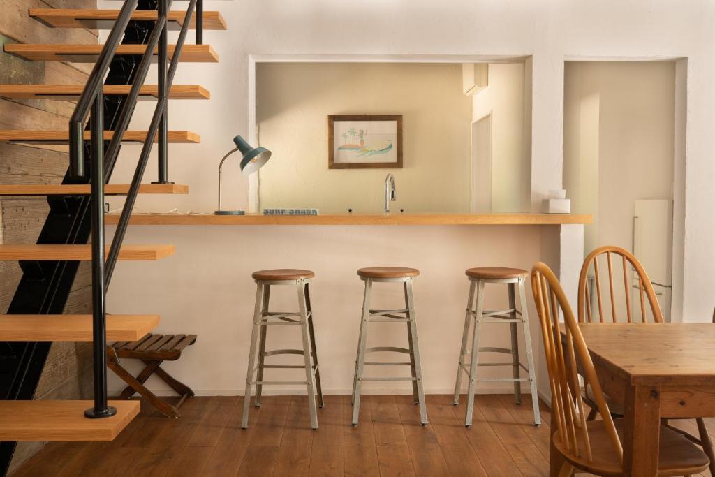 a kitchen with a bar with stools and a table at HAZcottage in Makinohara