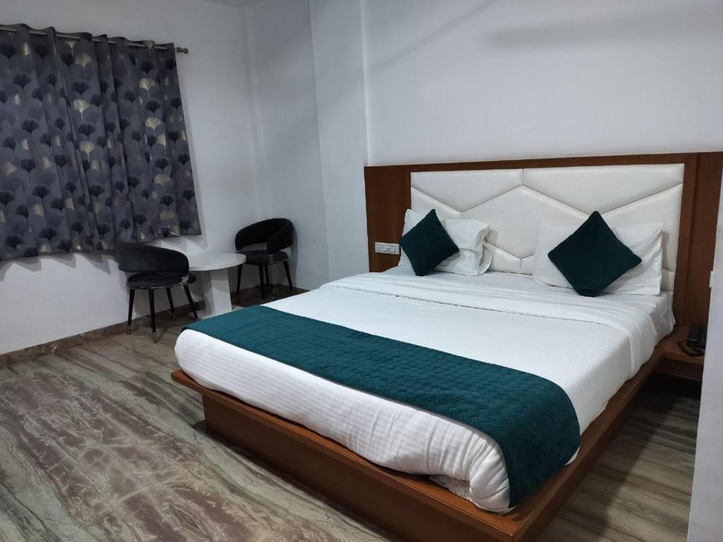Hotel Brij Palace & Restaurant في أودايبور: غرفة نوم فيها سرير كبير وكراسي