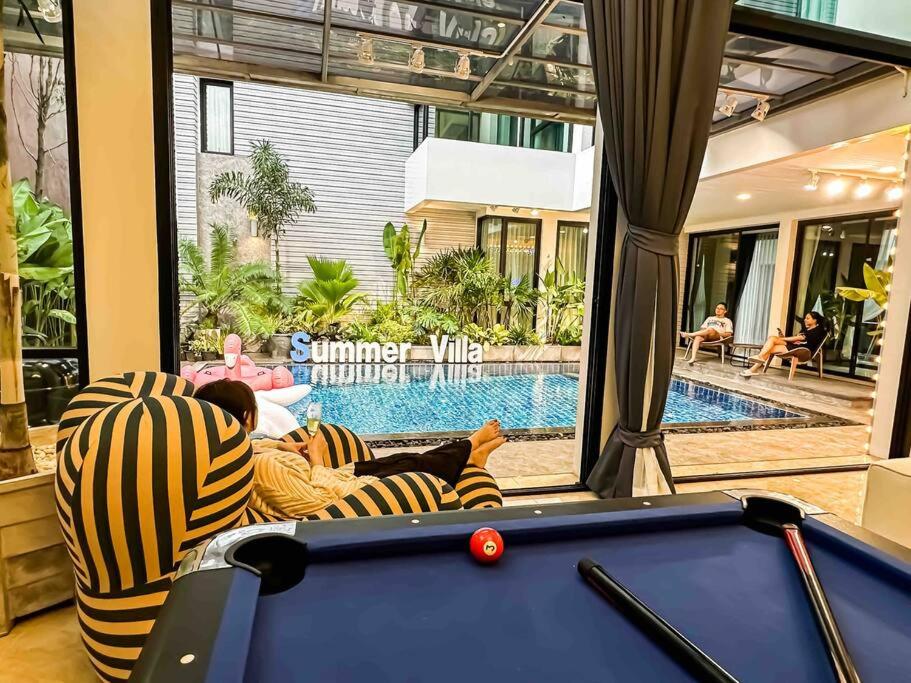 曼谷的住宿－summer villa 曼谷中心Asok&Thong Lor800平米海天别墅189/7，坐在台球桌旁沙发上的人