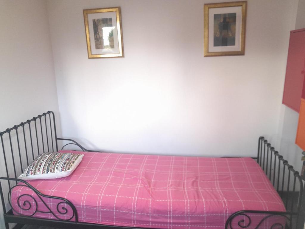 - un lit dans une chambre avec une couverture rose dans l'établissement Studio paisible orsay, à Orsay