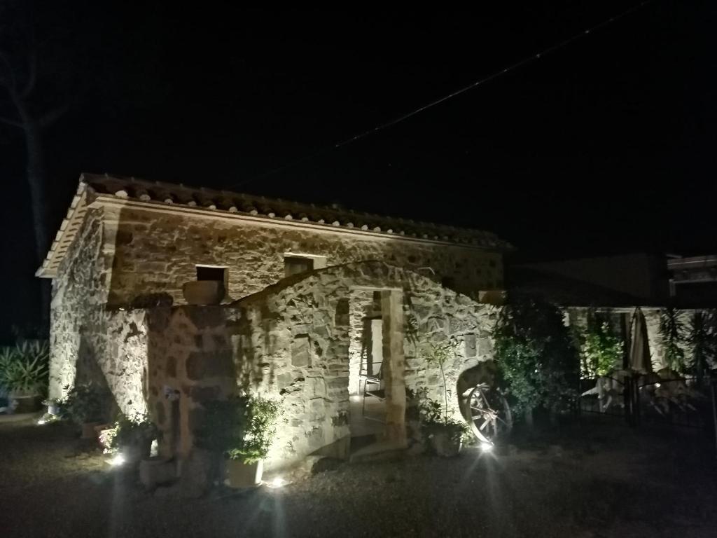 una casa de piedra por la noche con luces encendidas en Vecchio Casale Quercetino, en Montenero