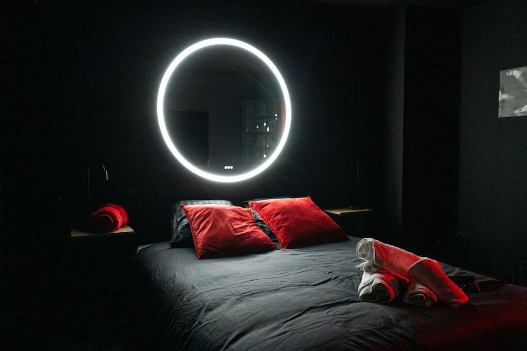 - une chambre avec un lit et un miroir rond dans l'établissement L’alcôve de la tentation, à Villeurbanne