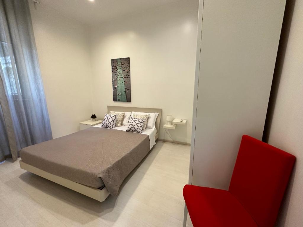 um quarto com uma cama e uma cadeira vermelha em Rome Holiday Home em Roma