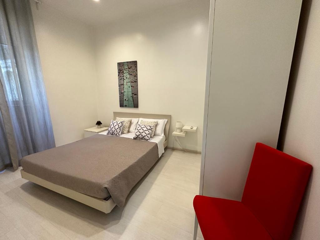 ローマにあるRome Holiday Homeのベッドルーム1室(ベッド1台、赤い椅子付)