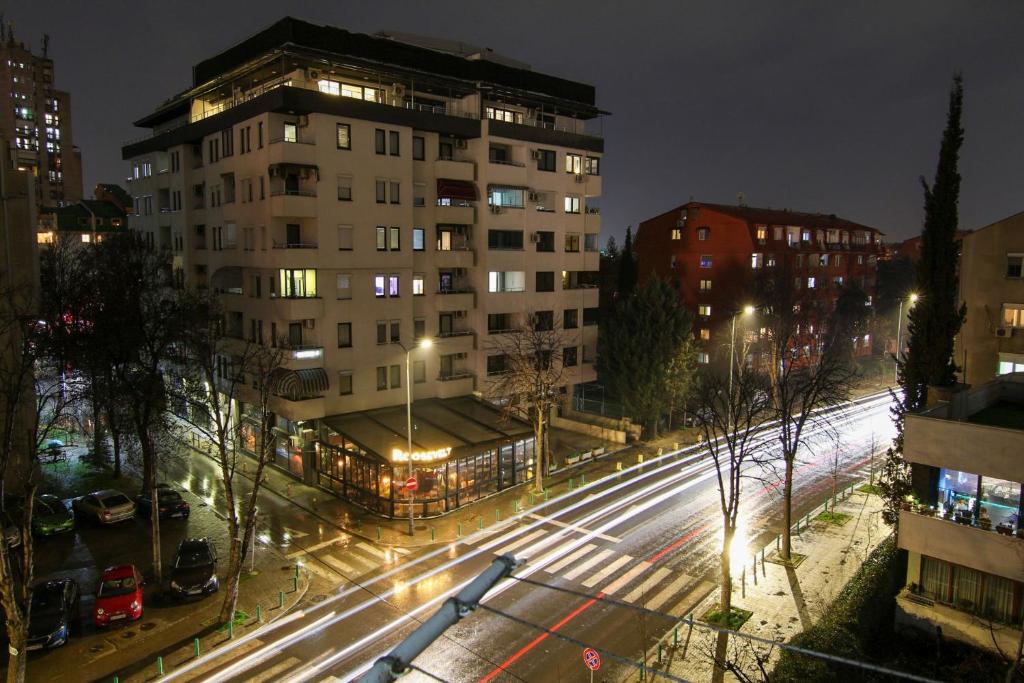 eine Stadtstraße in der Nacht mit einem hohen Gebäude in der Unterkunft Giovanni appartment in Skopje
