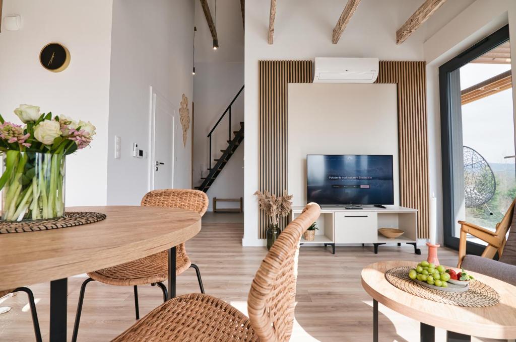 a living room with a table and chairs and a television at Apartamenty Laguna Beskidów - B39 in Zarzecze