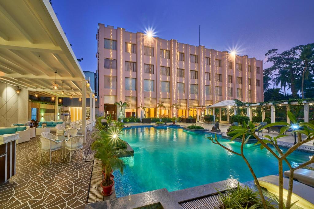 um hotel com piscina em frente a um edifício em Hotel Hindusthan International, Bhubaneswar em Bhubaneshwar