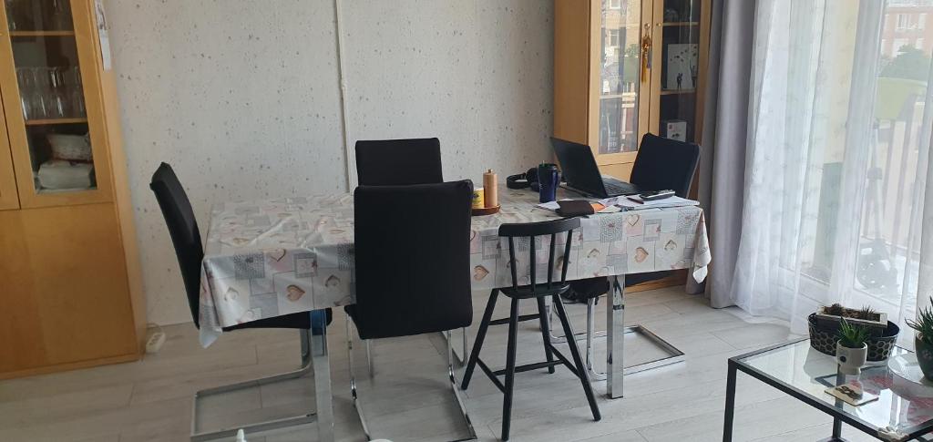 a dining room table with chairs and a table with two laptops on it at Chambre d&#39;hôte in Saint-Ouen