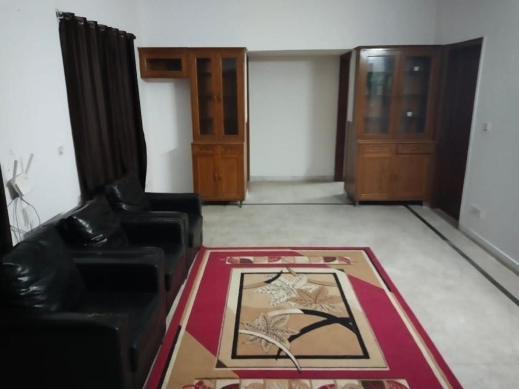 sala de estar con 2 sillas y alfombra en Hotel Heritage By ''ADA'', en Noida