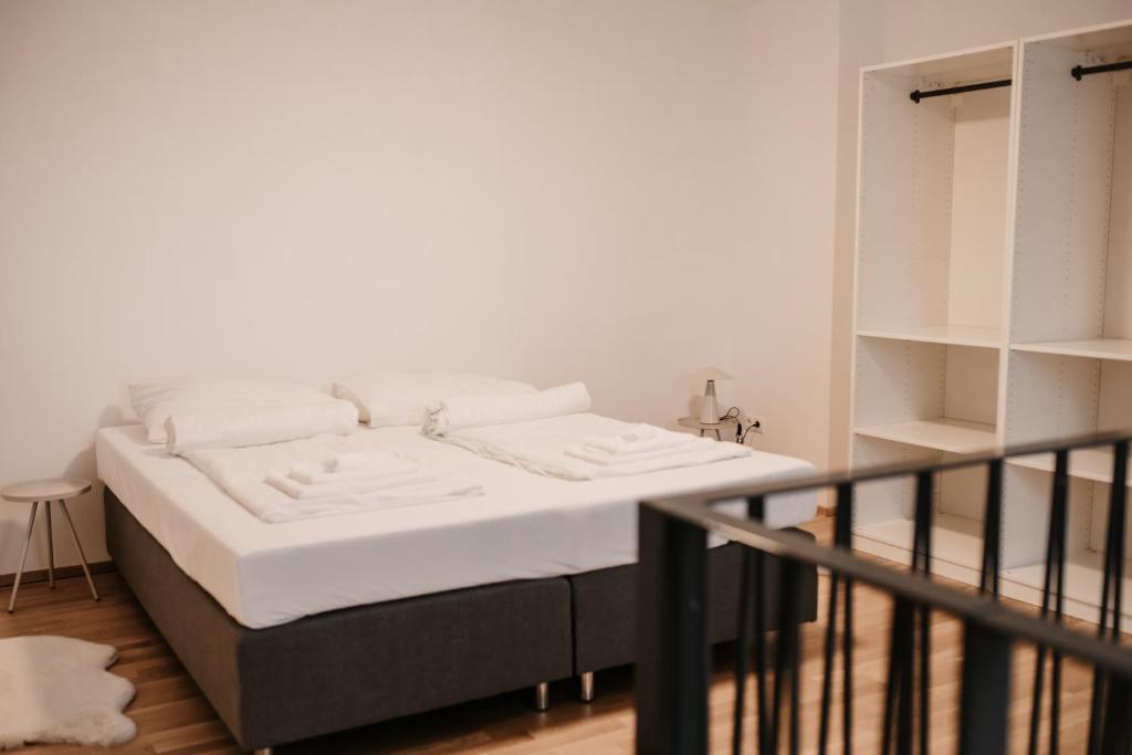 ein Bett in einem Zimmer neben einem Regal in der Unterkunft Modern Luxury Apartment Vienna in Wien