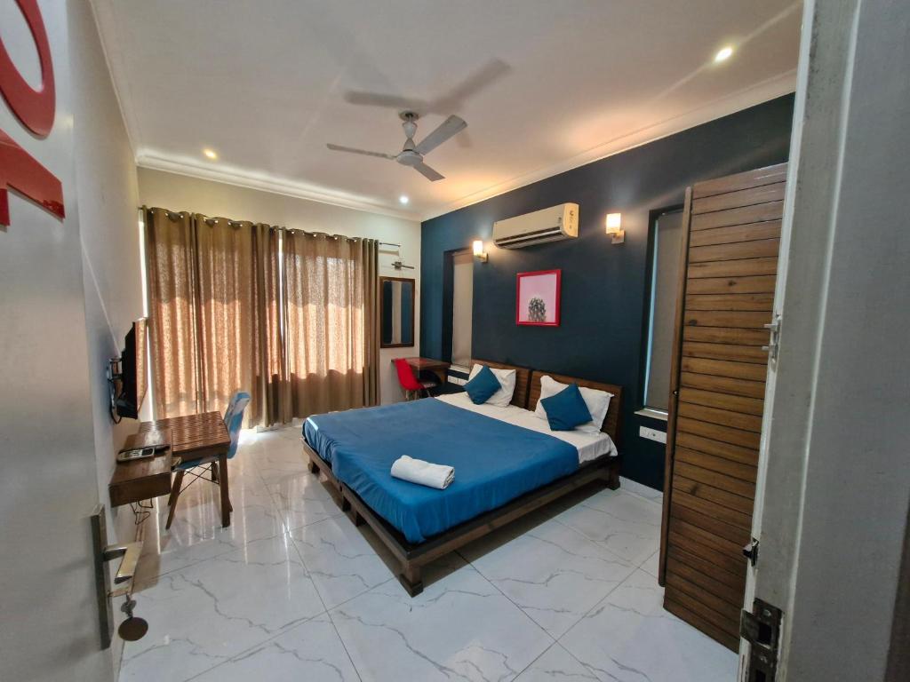 a bedroom with blue walls and a bed with blue sheets at Medenta square 39 in Gurgaon