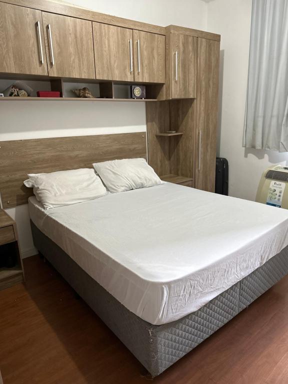 a large bed in a room with wooden cabinets at Apartamento no centro de Juiz de Fora in Juiz de Fora