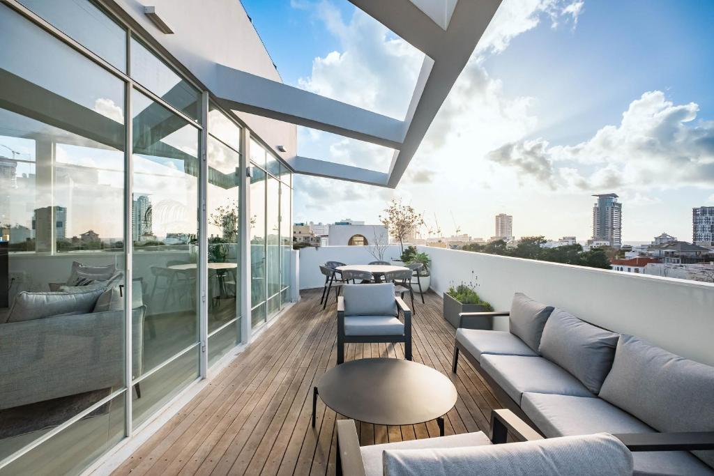 een balkon met een bank, stoelen en een tafel bij KG4 LUX Apartments in Tel Aviv