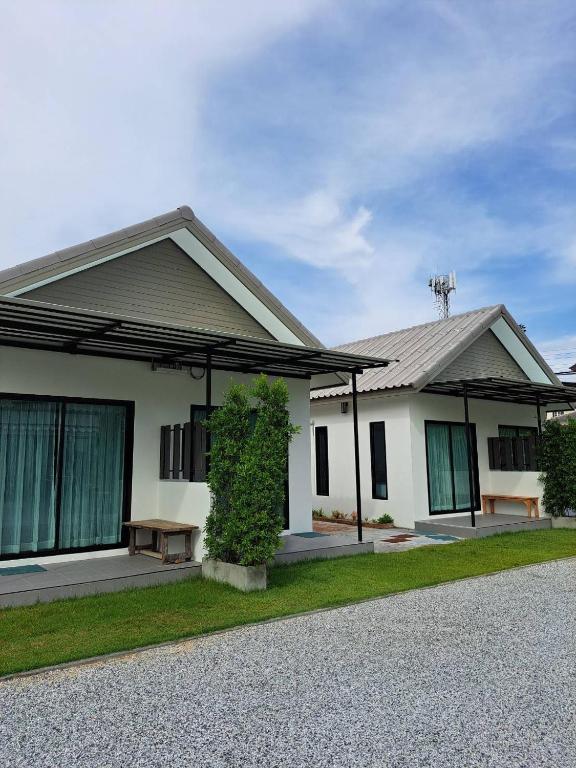 a white house with a bench in front of it at House number one in Ban Hua Khao Sammuk