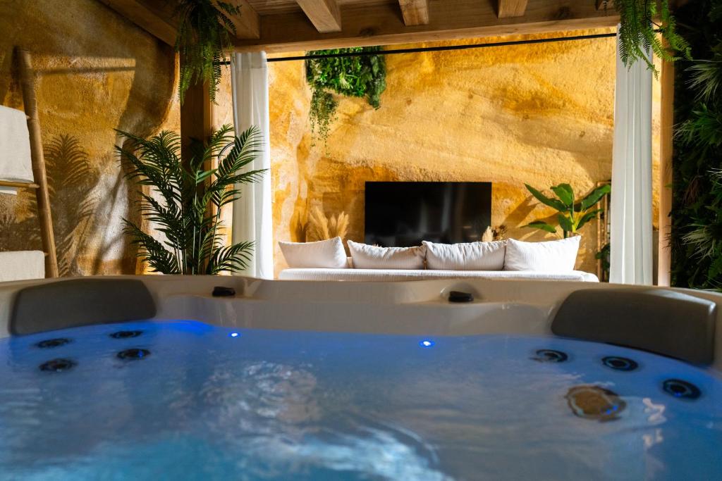 bañera en una habitación con sofá en el fondo en Le temps suspendu, Suite troglodyte & SPA privé, en Doué-la-Fontaine