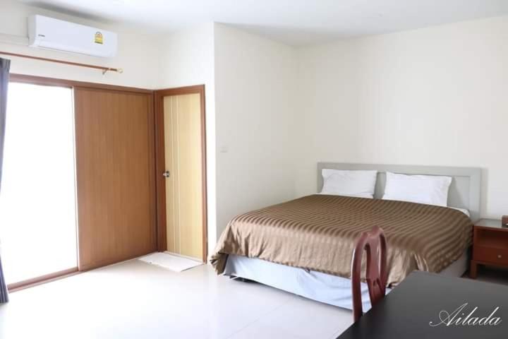 1 dormitorio con cama, mesa y puerta en Wonderland pool villa en Pattaya centro
