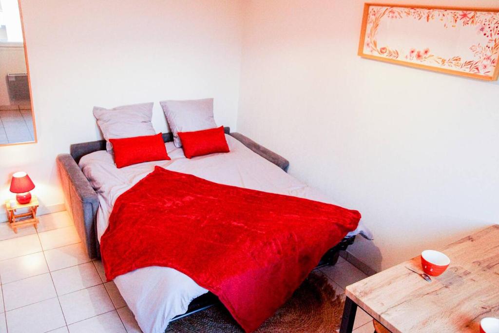 a bedroom with a bed with a red blanket on it at Proche rempart avec Parking sécurisé in Avignon