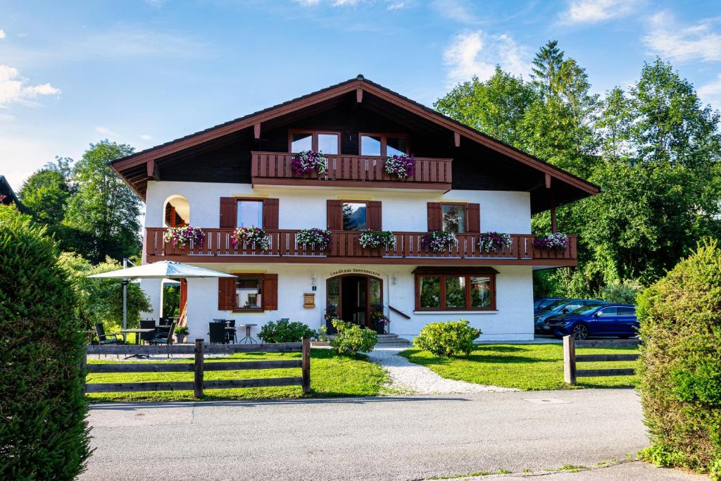 Großes weißes Haus mit Balkon in der Unterkunft Hotel Garni Landhaus Sonnenstern in Schönau am Königssee