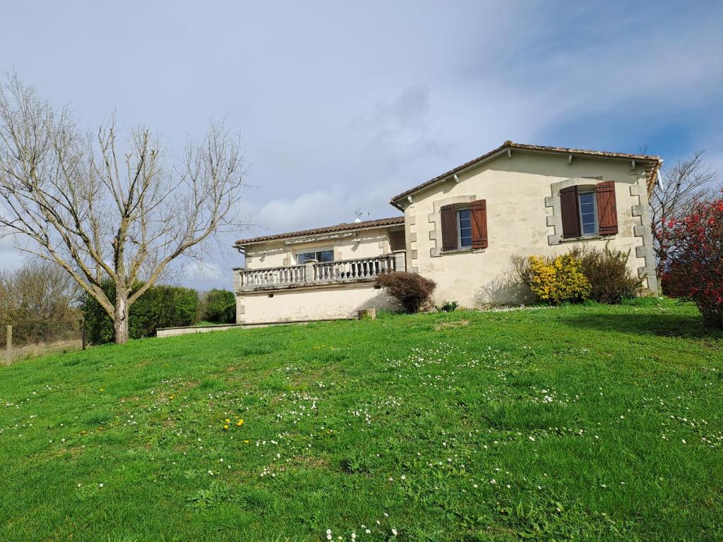 ein Haus auf einem Hügel mit einem großen Hof in der Unterkunft L'île Verte in Champagnac