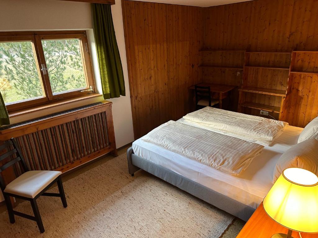 1 dormitorio con 1 cama, 1 silla y 1 ventana en Wald Appartement, en Gröbming