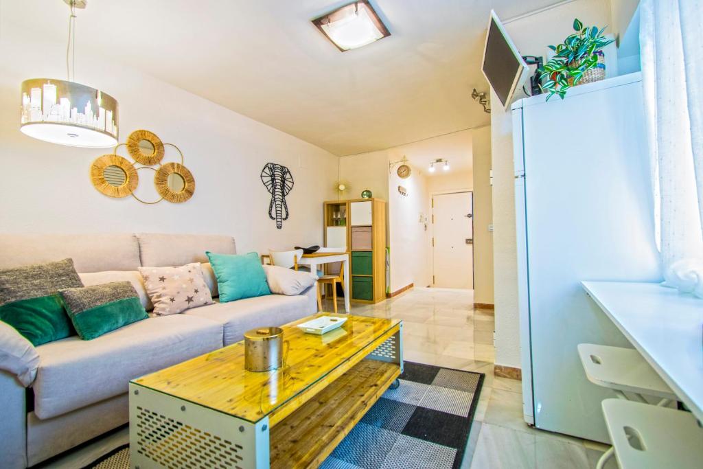 een woonkamer met een bank en een tafel bij Acogedor y coquetísimo apartamento de diseño muy, muy, muy Centrico in Sevilla