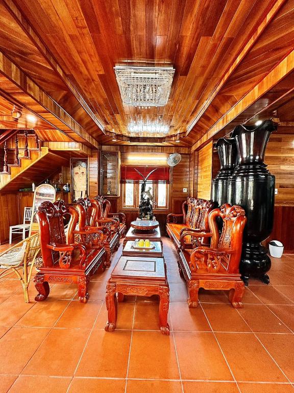ein Wohnzimmer mit Ledersesseln und einem Tisch in der Unterkunft Biệt thự gỗ Wooden House Quy Nhơn cạnh biển in Quy Nhon
