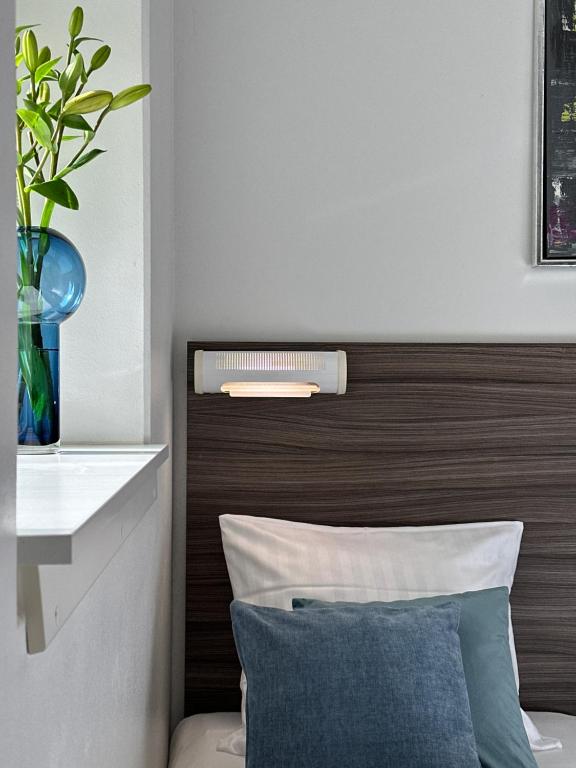a bedroom with a wooden headboard with a vase at ApartHotel Faber in Aarhus