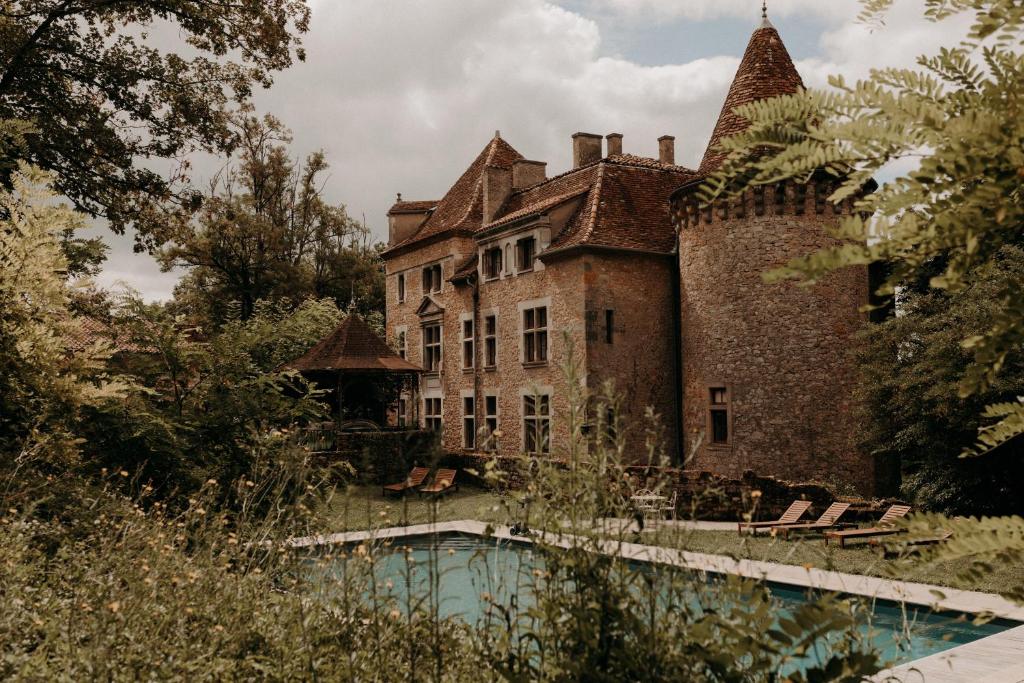 un antiguo castillo con una piscina frente a él en Chateau de Saint Dau, en Figeac