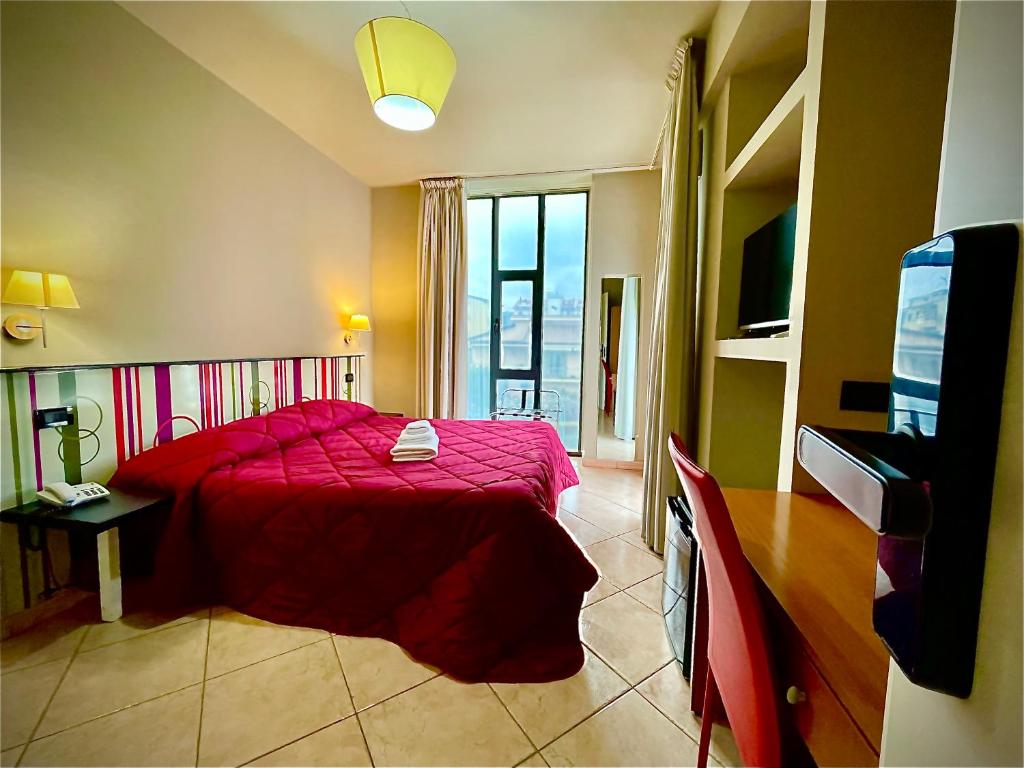 - une chambre avec un lit rouge et une télévision dans l'établissement Le Ceramiche - Hotel Residence ed Eventi, à Montalto Uffugo