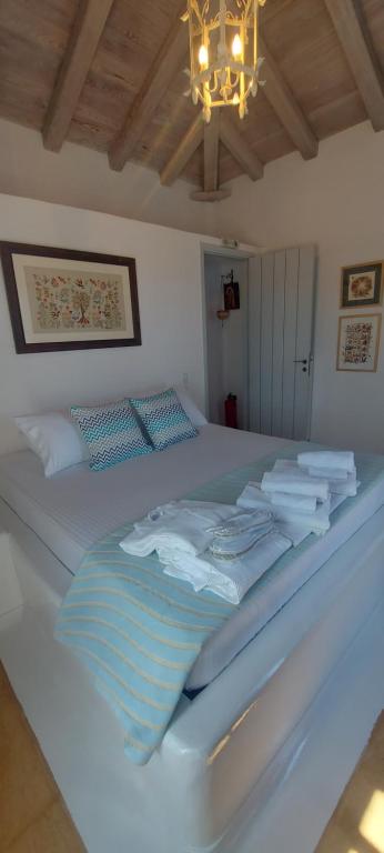 a bedroom with a white bed with a chandelier at Simos suites in Elafonisos