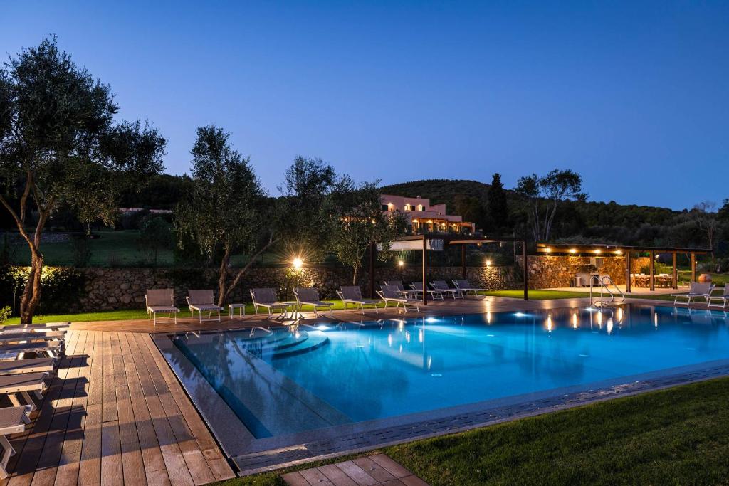 a swimming pool with chairs and a house in the background at Borgo Isasco in Finale Ligure